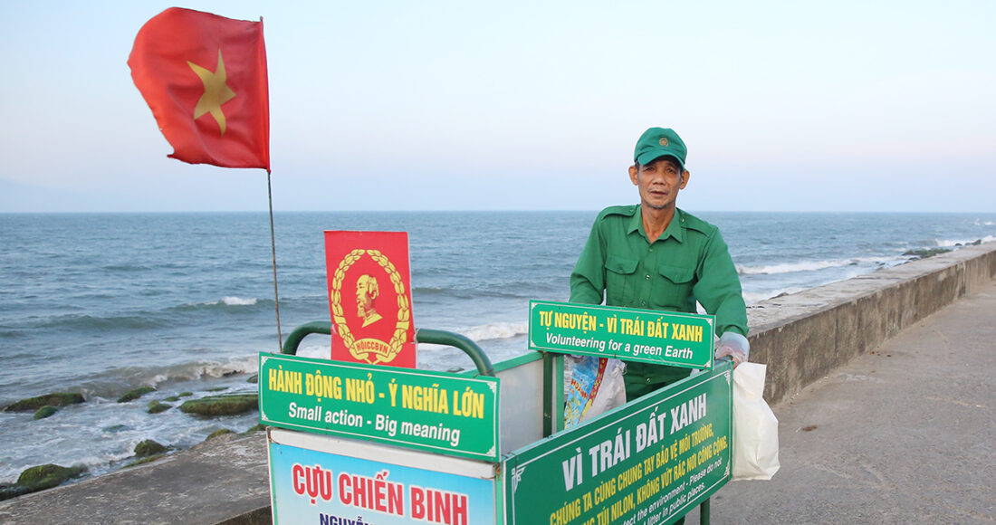 Ông Nguyễn Thương đẩy xe đi dọc bờ kè biển Cửa Đại nhặt rác. Ảnh: Đắc Thành