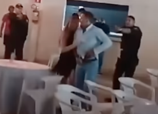 Khoảnh khắc ông Sebastiao Francisco rút súng từ bao thắt lưng và xả súng vào ban giam khảo, trong khi con gái ngăn cản và cảnh sát đang vây quanh. Ảnh: Uol