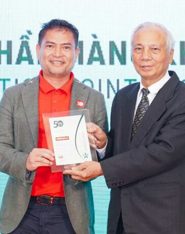 Ông Nguyễn An Di - Giám đốc Nhân sự Vietjet (áo T - shirt đỏ, áo khoác ghi xám) nhận giải thưởng tôn vinh Top 50 doanh nghiệp phát triển bền vững từ ban tổ chức