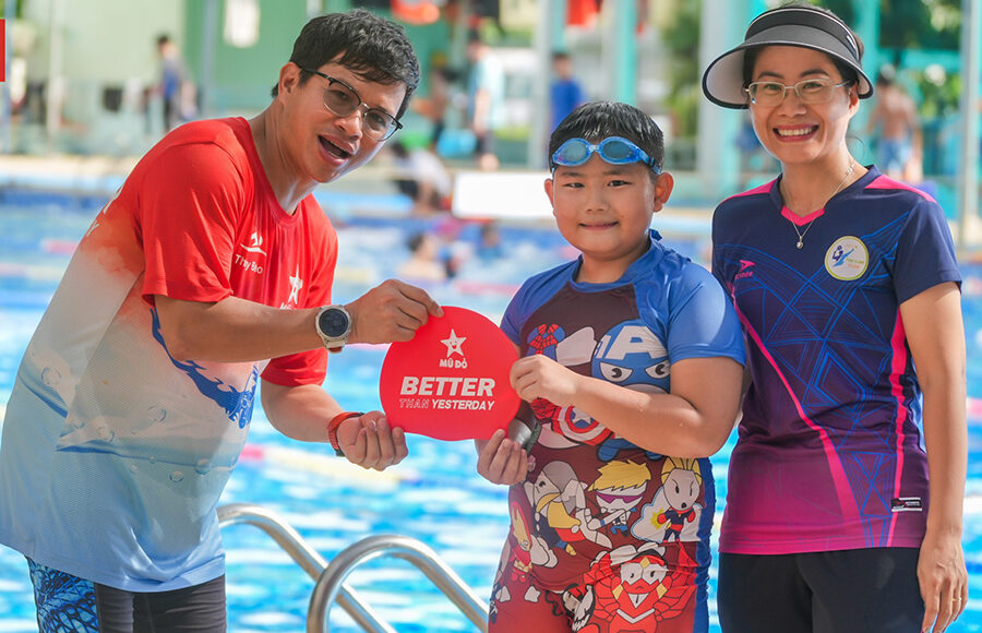 Anh Nguyễn Văn Thủy trao giải Vượt qua chính mình cho một học viên trong Câu lạc bộ Mũ đỏ tại bể bơi quận Thanh Xuân, giữa tháng 7/2024. Ảnh: N.V.T