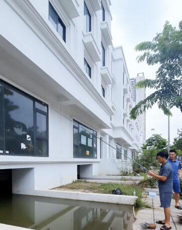 Một người đàn ông câu cá rô trong các hầm để xe của dãy biệt thự, shophouse trên đường Lê Trọng Tấn, huyện Hoài Đức, chiều 28/7. Ảnh: Phạm Hà