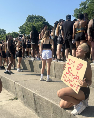 Một thành viên nữ của câu lạc bộ Chicago Run Collective chụp hình cùng tấm biển Tôi còn độc thân, hãy chạy cùng tôi trước giải chạy. Ảnh: CBS News