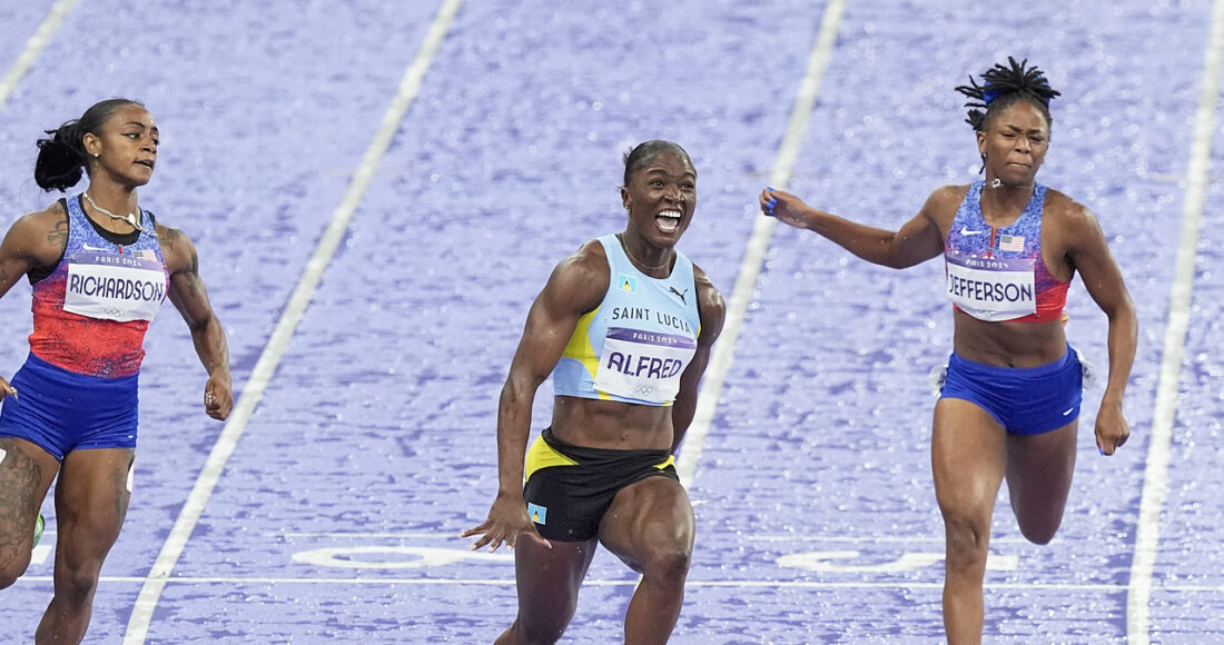 Julien Alfred (giữa) mừng chiến thắng khi cán đích đầu tiên ở nội dung 100m nữ Olympic 2024. Ảnh: AP.