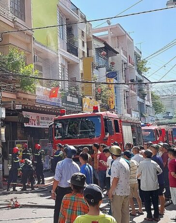 Người dân tập trung kín phía ngoài, trong khi xe cứu hoả nối đuôi nhau tiếp nước cho lính cứu hoả dập lửa. Ảnh: Văn Hồ