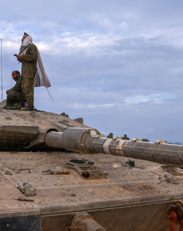 Binh sĩ Israel đứng, ngồi trên nóc xe tăng gần biên giới với Lebanon tháng 10/2023. Ảnh: AFP