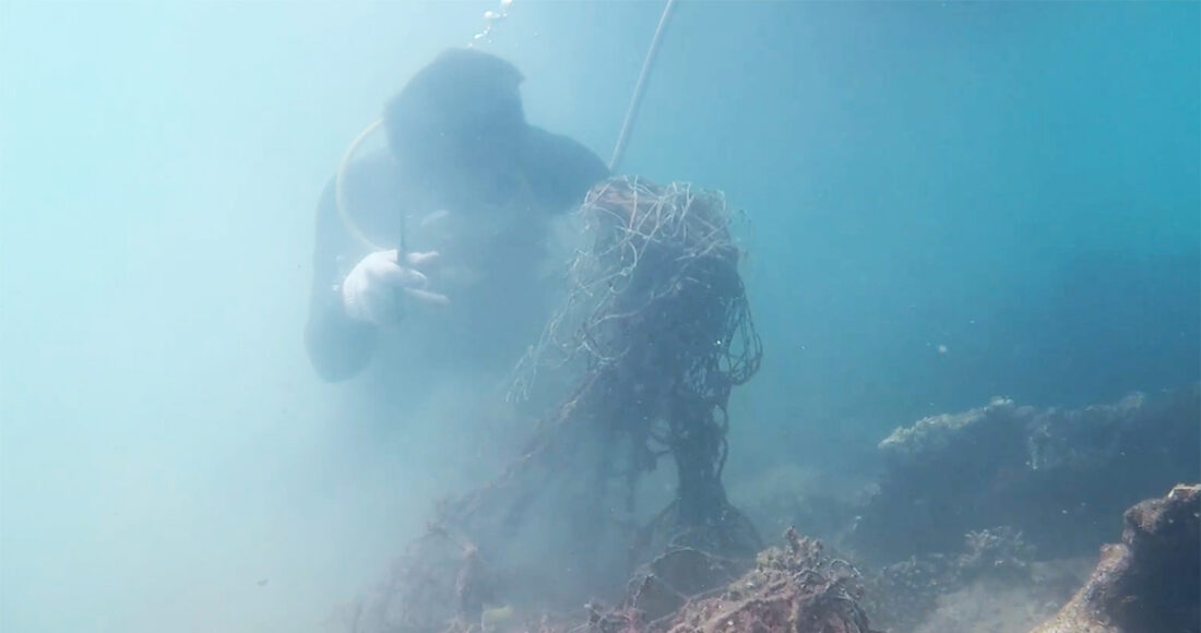 Thợ lặn cắt lưới đánh cá trùm lên rạn san hô. Ảnh: Vườn quốc gia Côn Đảo