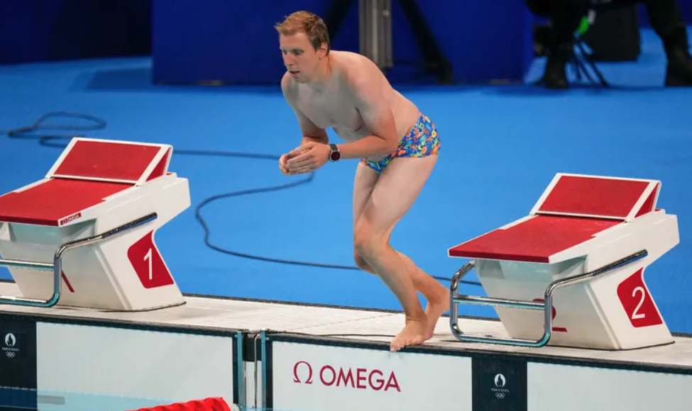 Nam nhân viên nhảy xuống bể để vớt mũ cho kình ngư Emma Weber. Ảnh: AP