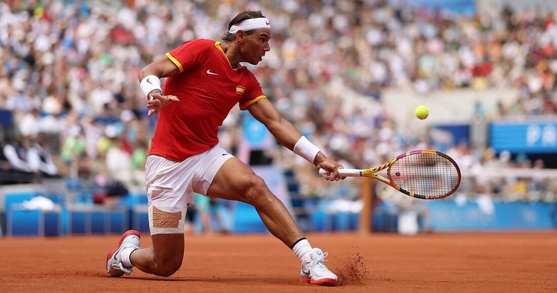Nadal cắt bóng ở trận gặp Fucsovics, trên sân Philippe Chatrier, Paris hôm 28/7. Ảnh: Reuters