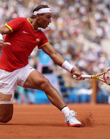 Nadal cắt bóng ở trận gặp Fucsovics, trên sân Philippe Chatrier, Paris hôm 28/7. Ảnh: Reuters
