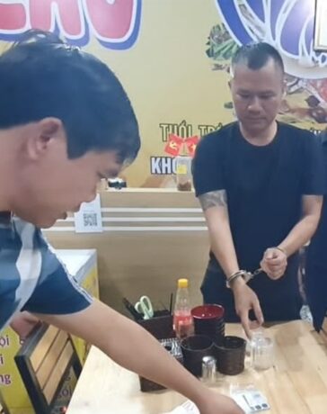 Huy (đeo còng tay) khi bị bắt. Ảnh Công an cung cấp