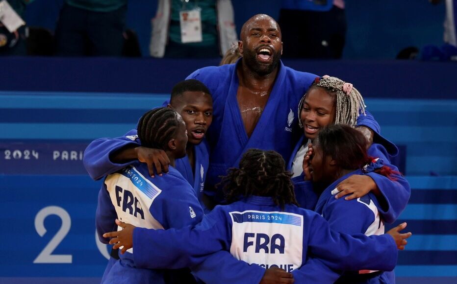 Riner (giữa) và các đồng đội mừng chiến thắng 4-3 cho Pháp trong trận chung kết đồng đội hỗn hợp nam - nữ với Nhật, nội dung thi đấu cuối cùng của môn judo, ngày 3/8. Ảnh: Le Parisien