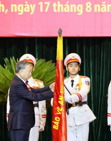 Tổng Bí thư, Chủ tịch nước Tô Lâm gắn huân chương danh hiệu Anh hùng Lực lượng vũ trang nhân dân lên cờ truyền thống lực lượng Công an TP HCM. Ảnh: Quốc Thắng