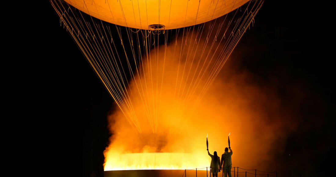 Nam võ sĩ judo Teddy Riner và nữ VĐV điền kinh Marie-Jose Perec sau khi châm đuốc lên vạc ở vườn Tuileries, quận 1, thành phố Paris, Pháp, trong lễ khai mạc Olympic tối 26/7/2024. Ảnh: AFP