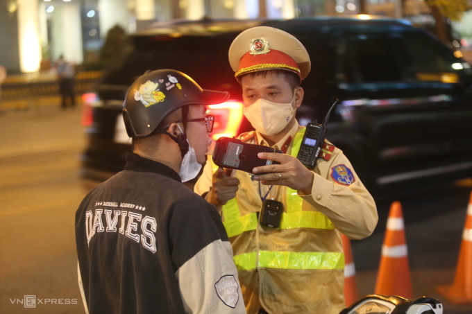 Cảnh sát đo nồng độ cồn người đi xe máy ở đường Huỳnh Thúc Kháng, Hà Nội. Ảnh:Gia Chính