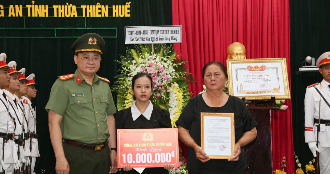 Vợ và mẹ liệt sĩ Trần Duy Hùng nhận bằng Tổ quốc ghi công. Ảnh: Trần Hồng