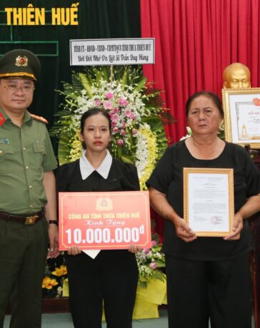 Vợ và mẹ liệt sĩ Trần Duy Hùng nhận bằng Tổ quốc ghi công. Ảnh: Trần Hồng