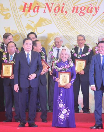 Chủ tịch Quốc hội Trần Thanh Mẫn (hàng đầu, bên trái) trao bằng khen cho PGS.TS, Nhà giáo nhân dân, AHLĐ Nguyễn Thị Trâm, một trong 135 trí thức được vinh danh. Ảnh: Quang Duy
