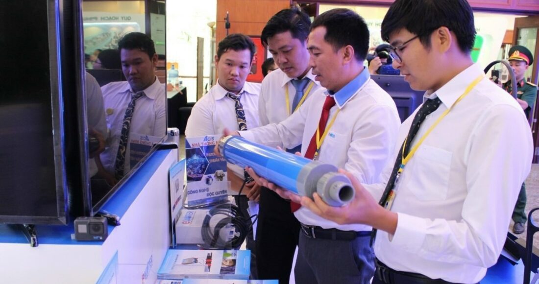 Kỹ sư Lê Trung Hiếu (giữa) giới thiệu sản phẩm xử lý cáu cặn trên ống nước ở một triển lãm tại TP HCM năm 2020. Ảnh: NVCC