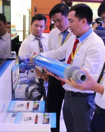 Kỹ sư Lê Trung Hiếu (giữa) giới thiệu sản phẩm xử lý cáu cặn trên ống nước ở một triển lãm tại TP HCM năm 2020. Ảnh: NVCC