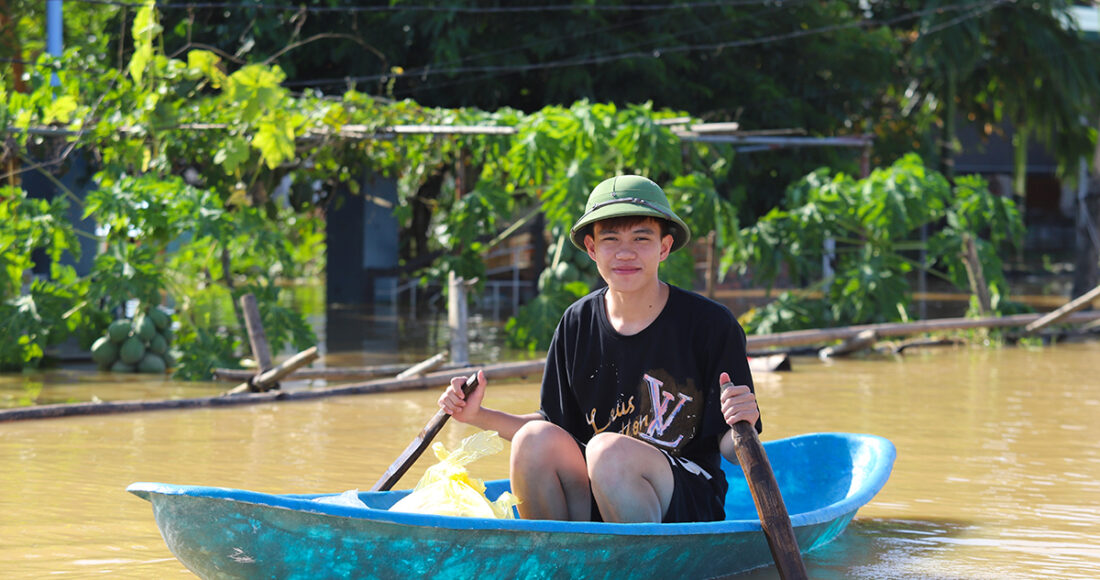 Kiên đang chèo thuyền đi đưa hàng cứu trợ cho người dân thôn 9, chiều 12/9. Ảnh: Đức Hùng