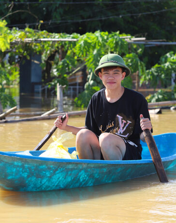 Kiên đang chèo thuyền đi đưa hàng cứu trợ cho người dân thôn 9, chiều 12/9. Ảnh: Đức Hùng