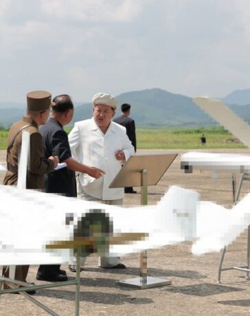 Ông Kim Jong-un bên cạnh hai mẫu UAV tự sát trong chuyến thăm hôm 24/8. Ảnh: KCNA