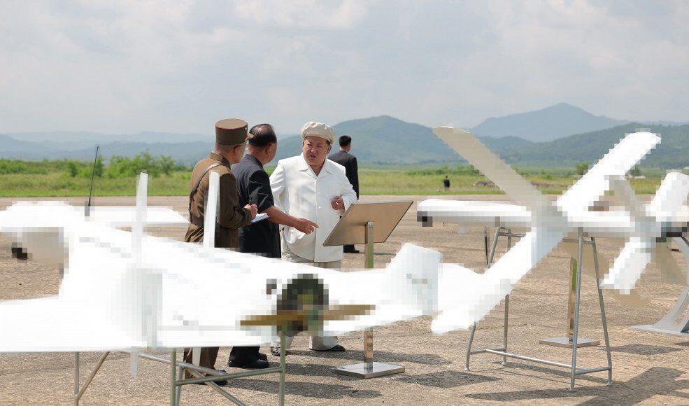 Ông Kim Jong-un bên cạnh hai mẫu UAV tự sát trong chuyến thăm hôm 24/8. Ảnh: KCNA