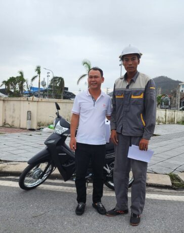 Anh Hoàng Ngô Quý (áo xám) nhận chiếc xe máy mới từ anh Lê Văn Quân (áo trắng) tại thành phố Cẩm Phả, tỉnh Quảng Ninh, sáng 23/9. Ảnh: Người Quảng Ninh