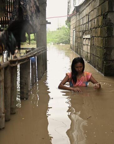 Người phụ nữ lội qua con hẻm ngập nước ở khu vực phía bắc Manila, Philippines ngày 4/9. Ảnh: Reuters