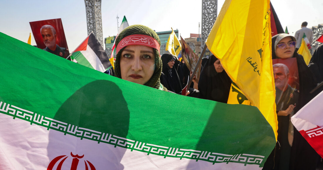 Người phụ nữ cầm cờ Iran diễu hành trên phố Tehran ngày 2/10. Ảnh: AFP