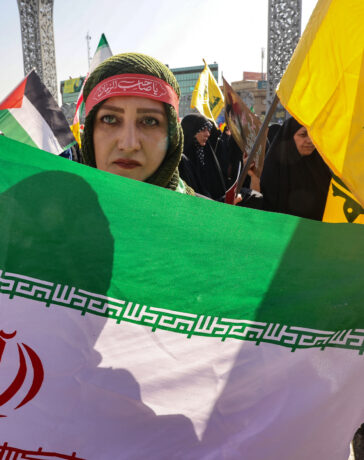 Người phụ nữ cầm cờ Iran diễu hành trên phố Tehran ngày 2/10. Ảnh: AFP