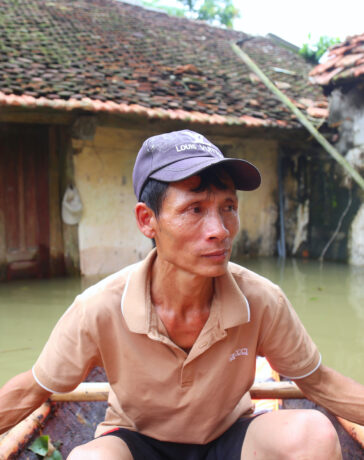 Ông Nguyễn Văn Bình chèo thuyền về thăm nhà, trưa 12/9. Ảnh: Phạm Dự