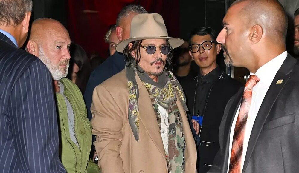 Johnny Depp diện áo khoác dài phối cùng giày họa tiết sơn phun tại sự kiện ngày 30/9. Ảnh: GC Images
