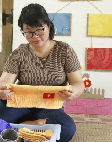 Cô Hoàng Thị Nự đang sắp xếp đồ dùng của học sinh đã mất để gửi về cho người thân. Ảnh: Thanh Hằng