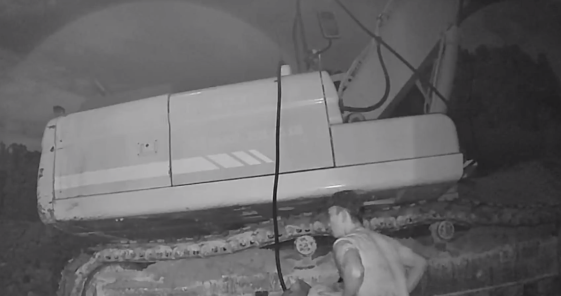 Camera ghi lại cảnh người đàn ông hút trộm dầu trong xe thi công.