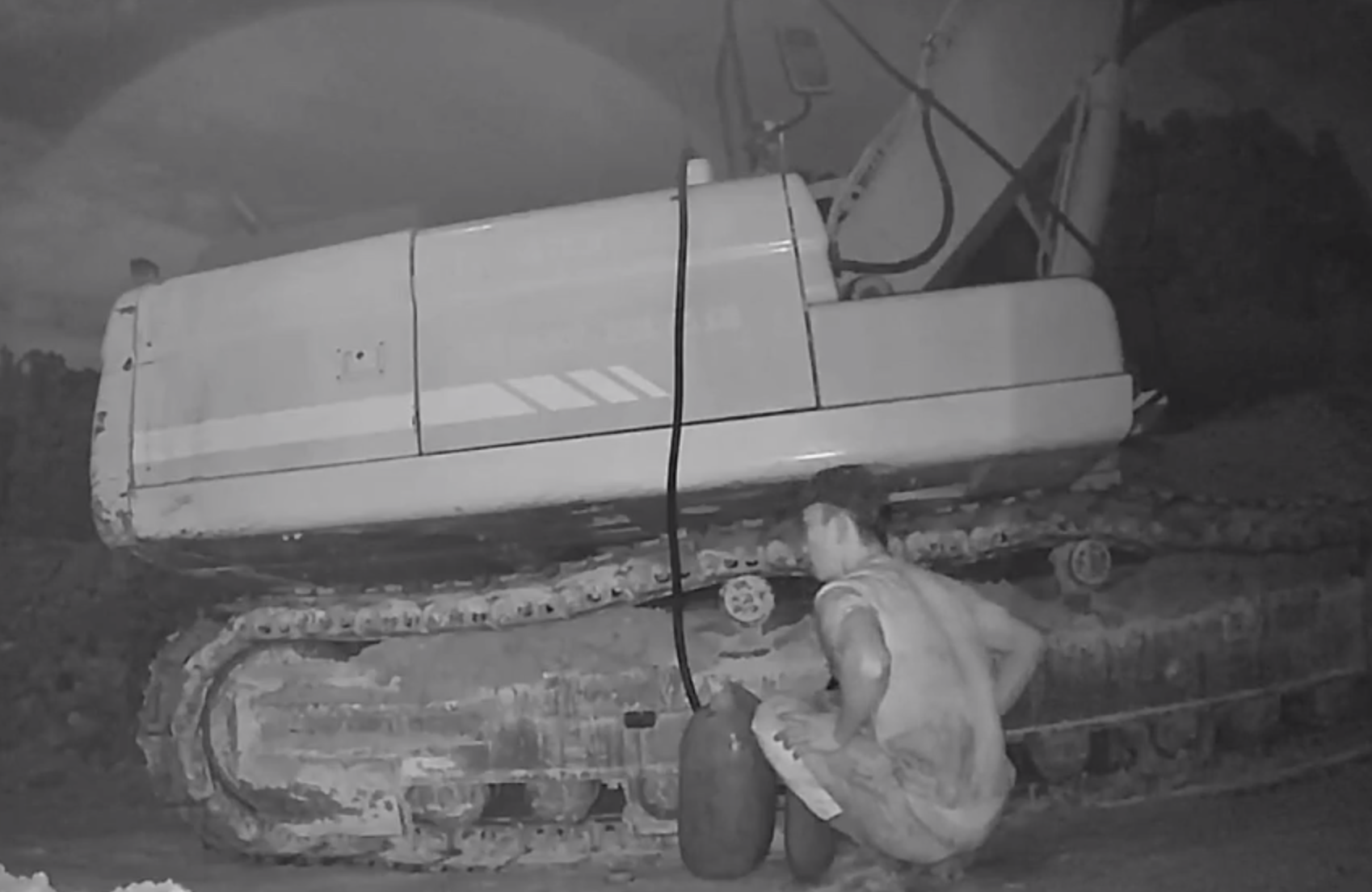 Camera ghi lại cảnh người đàn ông hút trộm dầu trong xe thi công.