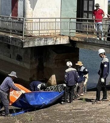 Lực lượng chức năng làm rọ đá và bạt vá lỗ thủng ở đập. Ảnh: Ngọc Oanh