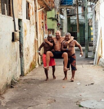 Adriano (giữa) vui vẻ bên hai người bạn trong khu ổ chuột ở Rio de Janeiro. Ảnh: The Players Tribune
