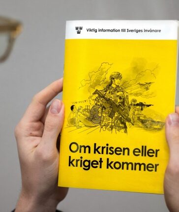 Người đàn ông cầm cuốn sổ Nếu khủng hoảng hoặc chiến tranh xảy ra tại Stockholm, Thụy Điển hôm 18/11. Ảnh: AFP