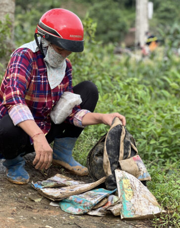 Người thân bên cặp sách còn sót lại của học trò Làng Nủ sau trận lũ quét rạng sáng 10/9. Ảnh: Hoàng Phương