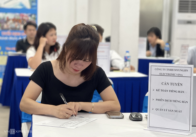 Bà Vân ghi lại thông tin ứng viên tiếng Hàn trong phiên tuyển dụng tại Hà Nội hồi tháng 11. Ảnh: Hồng Chiêu