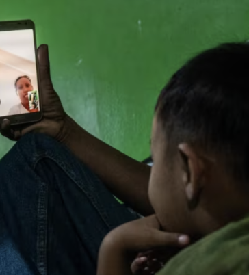 Bà Wahyuni trò chuyện với gia đình bà ở Indonesia qua cuộc gọi video. Ảnh: CNA