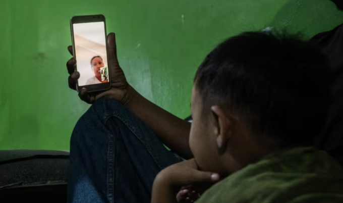 Bà Wahyuni trò chuyện với gia đình bà ở Indonesia qua cuộc gọi video. Ảnh: CNA