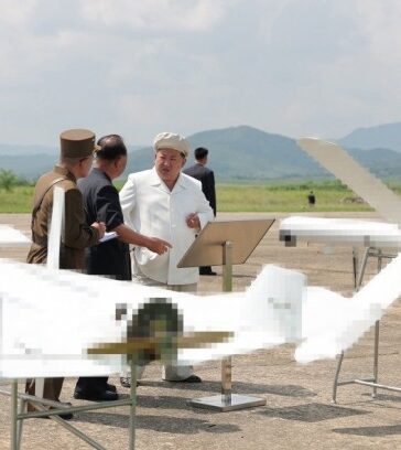 Ông Kim Jong-un bên cạnh hai mẫu UAV tự sát trong chuyến thăm hôm 24/8. Ảnh: KCNA