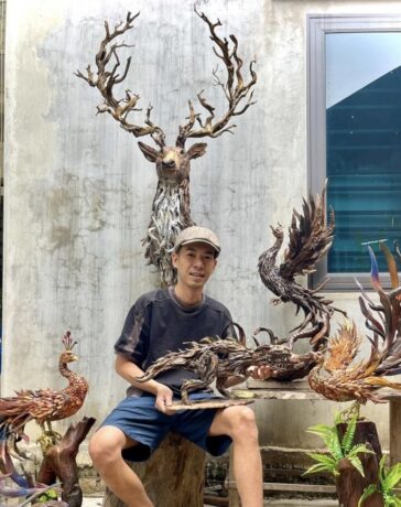 Huy bên những tác phẩm gỗ lữa từng làm. Ảnh: NVCC