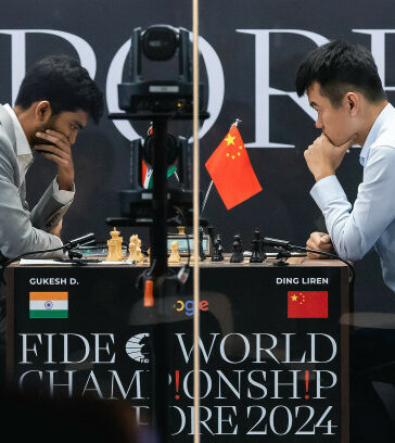 Đinh Lập Nhân (phải) trong ván đầu tiên gặp Gukesh ở trận chung kết cờ vua thế giới tại Singapore ngày 25/11/2024. Ảnh: FIDE